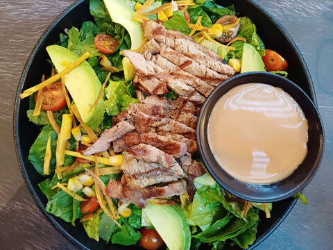Ensalada de vegetales, acompa&ntilde;ada de frituras, carne de res y trozos de queso. Toma Horizontal.