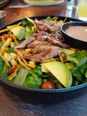 Ensalada de vegetales, acompañada de frituras, carne de res y trozos de queso. Plano Comensal