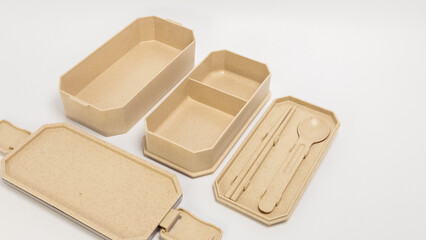 Eco-friendly lunch box set with compartments and cutlery on white background