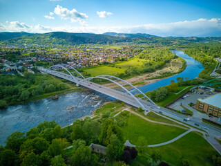View of the Dunajec River and the bridge in Nowy Sącz, a city in the Lesser Poland Voivodeship. - obrazy, fototapety, plakaty