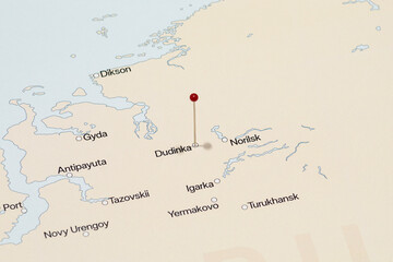 macro photo of a red pin needle into dudinka city of Russia political map