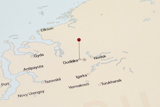 macro photo of a red pin needle into dudinka city of Russia political map
