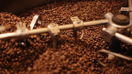 Many coffee shops use professional roasting equipment to make fresh aromatic ground coffee. Slow motion. Rotating roaster blades