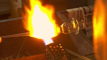 Detail of artisan glassblowing process using a torch to shape molten glass in Italian workshop - Powered by Adobe