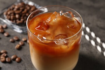 Tasty iced coffee and beans on grey table, closeup
