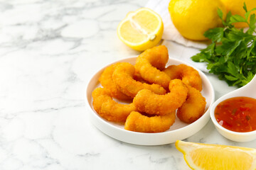 Tasty tempura shrimps and lemon on white marble table, closeup. Space for text