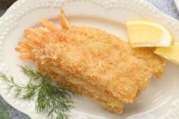 Tasty tempura shrimps, lemon and dill on grey table, top view