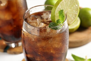 Tasty Cuba Libre cocktail in glass on table, closeup