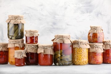 Many jars with different pickled products on light table. Space for text