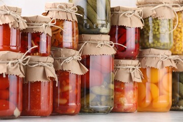 Many jars with different pickled products on light table