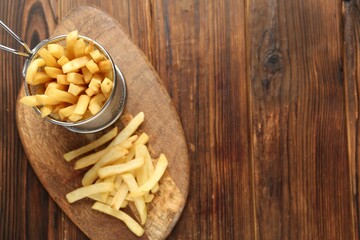 Tasty french fried served on wooden table, top view. Space for text