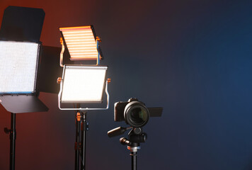 Professional lighting equipment and camera on color background. Space for text
