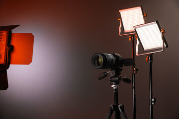 Professional lighting equipment and camera on color background. Space for text