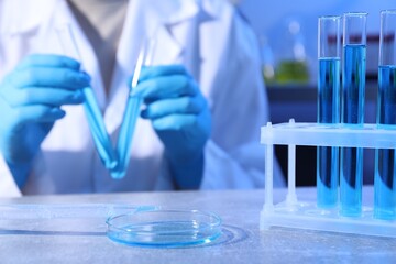 Petri dish and pipette with sample. Scientist working in laboratory, selective focus