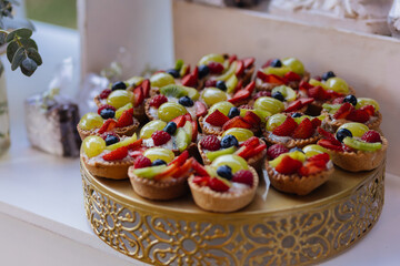 A beautifully arranged dessert table featuring mini berry cheesecakes, green grape tarts, and floral decor. The clean, natural style makes it ideal for events, catering, and gourmet branding. 