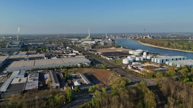 Drone flight over industrial area with factories, smokestacks and Rhine river view toward Leverkusen
