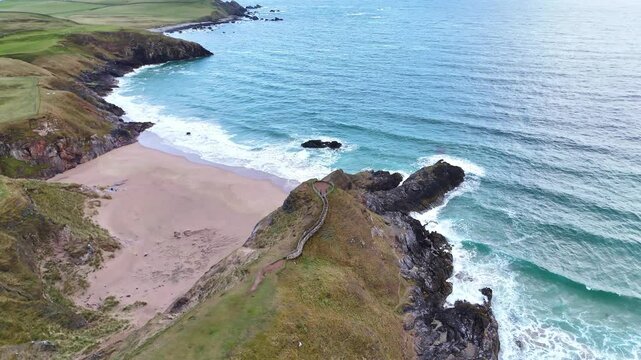 Drone view of sango sands viewpoint sea waves crashing the rocky cliffs at the daytime in Scotland