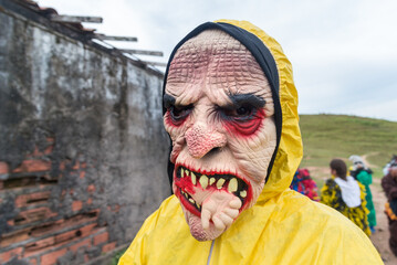 Unidentified person dressed in a horror costume in a rural area, playing and terrorizing other...