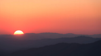 Obraz premium Pink and Orange Sunset Over Silhouetted Mountains