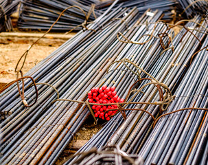 Steel reinforcement bars and red tying wires organized at a construction site in the early morning light