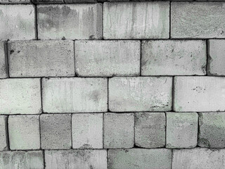 Weathered concrete brick wall with gray and green tones in urban setting