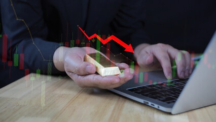 Businessman holding gold bars in hand, gold price falling, gold downtrend, gold trading idea, red arrow pointing down