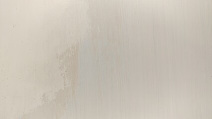 photograph emphasizing the texture of a limewash wall where the paint is actively peeling and flaking, revealing the underlying surface and the process of deterioration. 