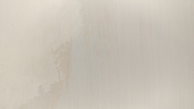 photograph emphasizing the texture of a limewash wall where the paint is actively peeling and flaking, revealing the underlying surface and the process of deterioration. 