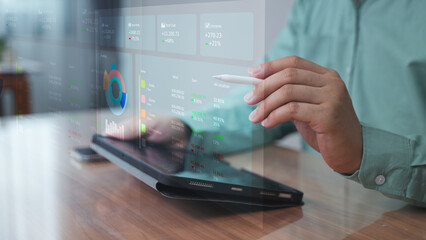 Professional using laptop with holographic dashboard and graphs – Data visualization and performance tracking concept in digital workplace.