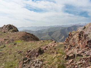 Chatkal Mountain Range in Tian Shan, Spring landscape in Uzbekistan under wispy clouds.
