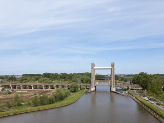 Netherlands civil engineering railway bridge in Dutch city Gouda, Hoge Gouwespoorbrug over Gouwe Canal train link transportation infrastructure connection on sunny day with cars 