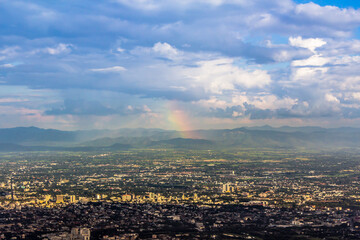 High angle view of Chiang Mai, Thailand with mountains and rainbow sky as a daytime backdrop.