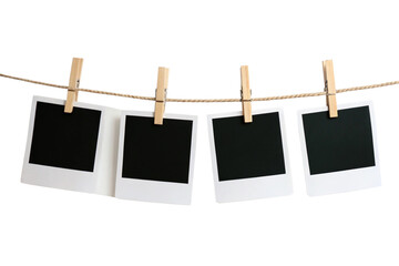 Four blank Polaroid photos clipped onto a rope with wooden pegs, evoking vintage vibes, ready to be filled with memories, set against a transparent background