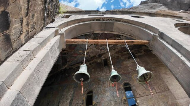 Vardzia, Georgia, May 1, 2025: bells at the Church of the Dormition entrance in Vardzia, highlighting ancient frescoes and a scenic sky