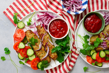 Chicken Lula Kebab with fresh vegetables and hot sauce on a platter.top veiw