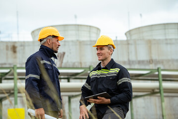 Engineer workers discussing work outdoor at oil refinery factory. Gas petroleum industry transport pipeline deploy building