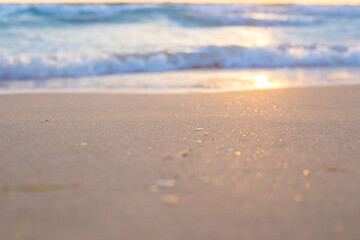 sand with golden reflections of sunlight and soft waves of the sea. seascape at sunset
