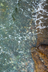 The water is calm and clear, with a few rocks scattered throughout