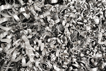 Shiny metal shavings texture. Curled and twisted silver steel spirals. Industrial waste after...