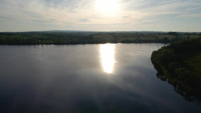 Peaceful picturesque sunset lake scene, sun reflecting on water. Emy Lough, Monaghan, Ireland