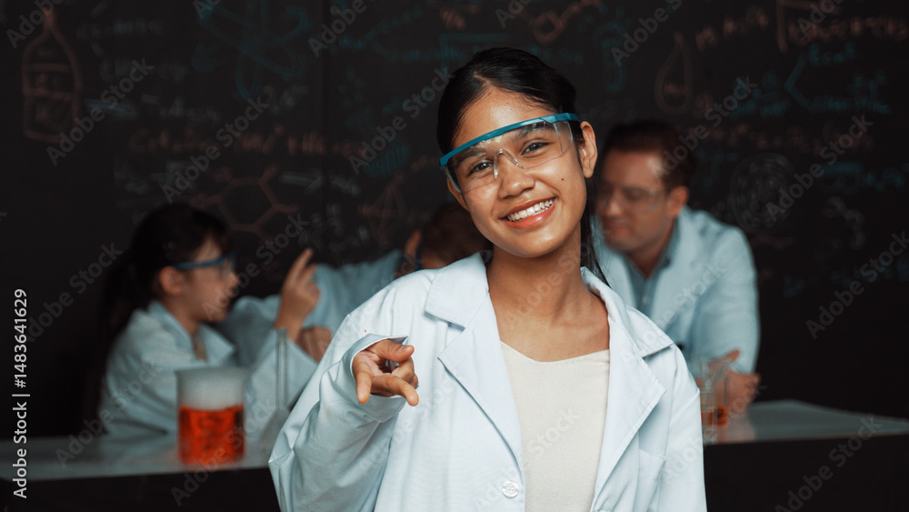 Poster highschool girl looking at camera while people doing experiment at laboratory. young cute student po