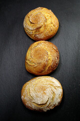 Three rye buns lie on a black background