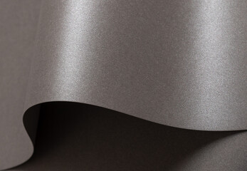 Gray glossy paper texture with a sleek, pearlescent finish, featuring wavy folds and edges. Elegant,