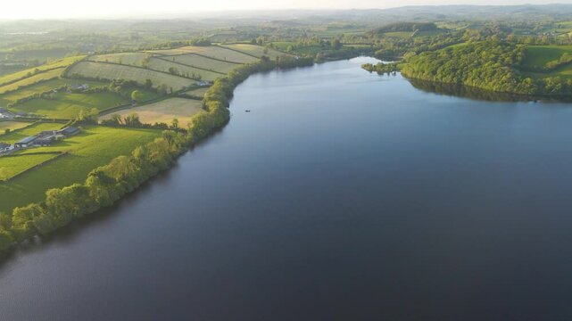 Blue lake surrounded by green fields in Irish countryside. Emy Lough, Monaghan, Ireland