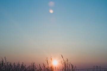 Frosty winter sunset in the field. Beautiful sunset in the snowy desert. Ice and sun..