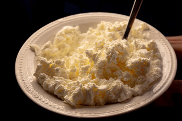 Cottage cheese with dramatic contrast lighting on a black background