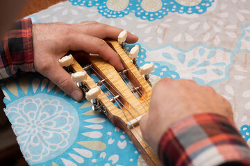 The guitar master checks the tension of the strings