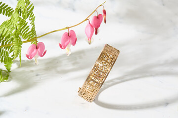 Gold Filigree Bracelet with Bleeding Heart Flowers on Marble
