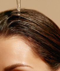Woman applying hair serum for nourishment and growth	