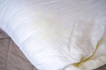 A white pillow with yellow spots.